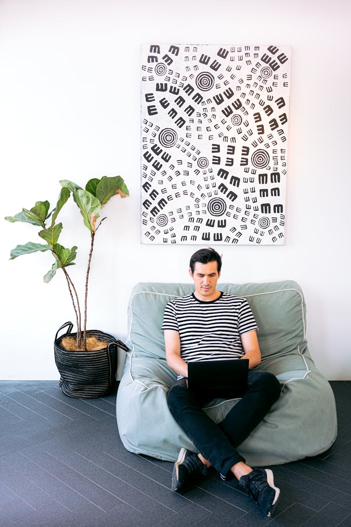 about-01 Young man working on laptop in stylish home office setting with modern decor.